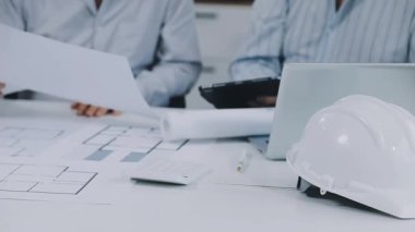 Ofisteki planlarla çalışan bir mimar
