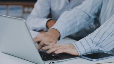 İş adamı dizüstü bilgisayar kullanıyor ve elini tutuyor..