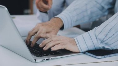 Laptopta yazan tişörtlü bir adam.