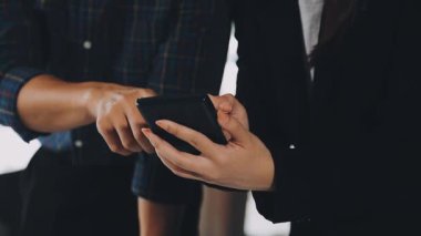 Ofiste akıllı telefon kullanan işadamı ve iş kadını.