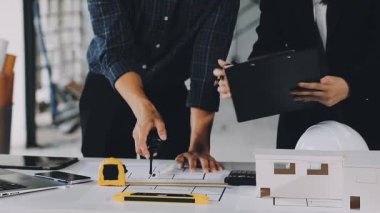 Masanın üzerinde taslak ile çalışan mimar mühendis ya da tasarımcı