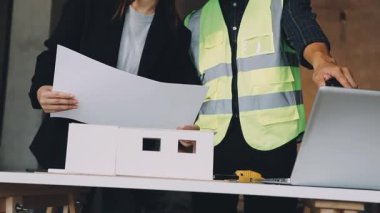 Bina planlarıyla inşaat alanında çalışan mühendis ya da mimar