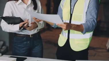 İnşaat alanının planlarıyla çalışan mimar, mühendis, mühendis, mühendis, mühendis.