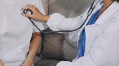 Hastanedeki hastanın steteskopunu tutan doktor.