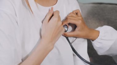 Doktor steteskoplu hastanın kan basıncını ölçüyor.