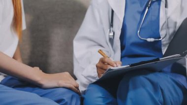 Doktor el ele tutuşuyor ve hasta hastane ofisinde masanın üzerinde oturuyor. tıp ve sağlık hizmeti kavramı.