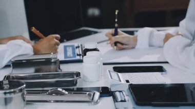 Profesyonel erkek doktor ofisinde bir dosya yazıyor..