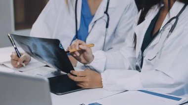 Üniformalı ve gözlüklü genç doktor bilgisayarda bir şey tartışıyor.