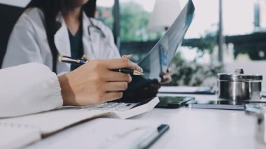 Yakın plan - not defterine not yazan kadın doktor.