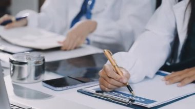 Bir grup tıp doktoru masada oturan hasta hakkında tartışıyor ve tartışıyorlar..