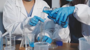 Laboratuvar önlüklü bilim adamı mikroskopla çalışıyor.