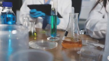 Bir kimya laboratuvarında çalışan bilim adamına yakın plan.