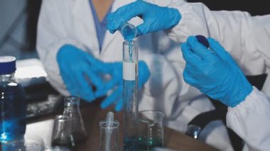 Laboratuvarda kimyasal şişesi olan bilim adamı.