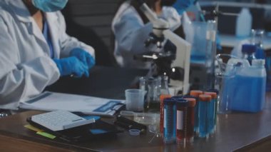 Laboratuvar araştırması. Koruyucu kıyafetli bilim adamı ellerinde sıvı olan bir test tüpü tutuyor. Bilim ve teknoloji. yüksek kaliteli fotoğraf