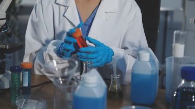 Elinde matara tutan bilim adamına yaklaş.