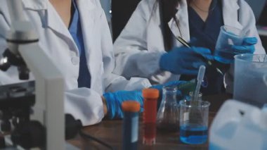 Kimyasal ekipmanlarla laboratuvarda çalışan bilim adamı.