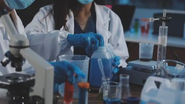 Laboratuvarda mikroskop üzerinde çalışan laboratuvar üniformalı bilim adamı. Bilim ve eğitim