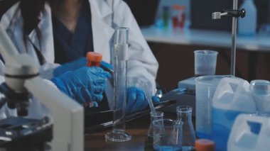 Laboratuvarda deney tüpü tutan bilim adamının yakın çekimi.