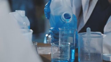 Yakın plan - Laboratuvar asistanının laboratuarda sıvı ile deney tüpü tutması.