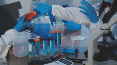 Laboratuvarda kimyasal test tüpleriyle çalışan bilim adamları