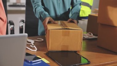 Paket kutusu ve dizüstü bilgisayarı olan teslimatçı.