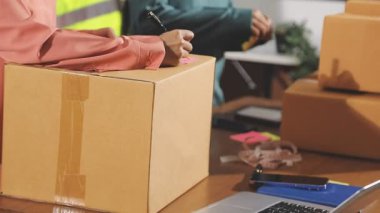 Genç bayan, ofisteki müşteri için paket hazırlıyor.