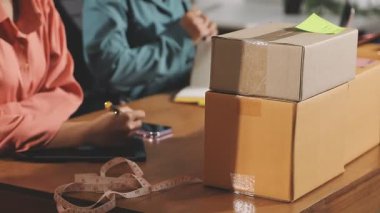 Ofiste elinde paket ve paket kutusu olan bir adam var. Yakın plan.