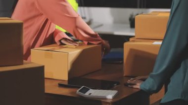 Asyalı bir kadın karton kutuyu paketle birlikte çevrimiçi teslimat servisindeki müşteriye paketliyor, çevrimiçi nakliye, paket teslimatı, çevrimiçi nakliye, iş konsepti, çevrimiçi servis