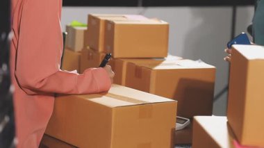 Kadın evdeki müşteriye teslimat paketi göndermek için dizüstü bilgisayar kullanıyor.