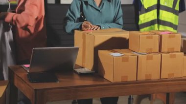 Paketi olan teslimatçı kadın depoda.