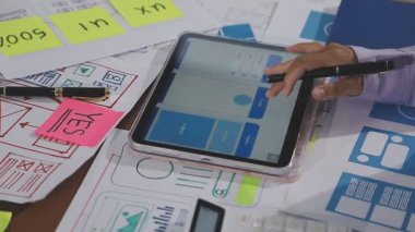 İş yerinde tableti ve akıllı telefonu olan genç bir iş kadını..