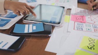 İş kadını elinde cep telefonuyla tablet tutuyor.