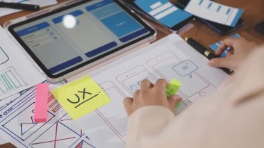 Kadın akıllı telefonuna yapışkan notlar yazıyor.