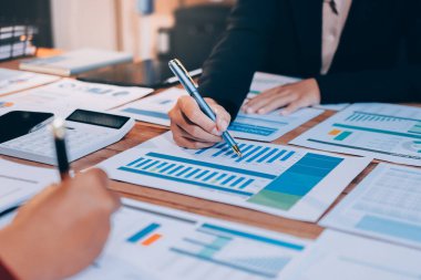 Bir grup iş adamı, analitik plan toplantısında beyin fırtınası yaparak grafikten elde edilen rakamları hesaplıyor. Finansal büyüme tablosu. Pazarlama. İş başarısı istatistikleri kavramı.