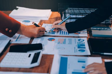 Bir grup iş adamı, analitik plan toplantısında beyin fırtınası yaparak grafikten elde edilen rakamları hesaplıyor. Finansal büyüme tablosu. Pazarlama. İş başarısı istatistikleri kavramı.