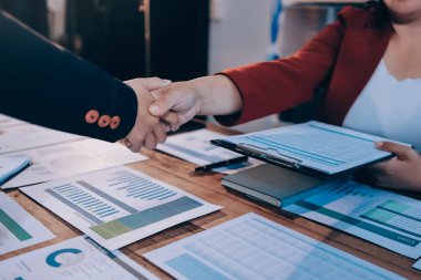 Ofis toplantısında iki farklı profesyonel iş adamı yönetici lider el sıkışıyor.