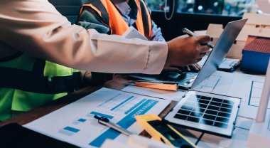 Mühendisler proje türlerinin yapısal analizi ve planları üzerinde çalışmalara yardım ediyorlar..