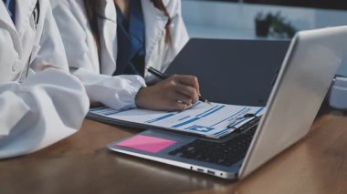 Hastane ofisindeki hasta ve dizüstü bilgisayarı kullanarak doktorun elini kapat..