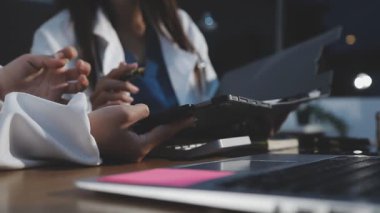 Kadın doktor ofiste tablet bilgisayar kullanıyor.