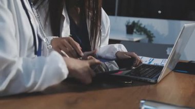 Diz üstü bilgisayarla çalışan doktor..