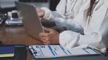 Klinikteki iş yerinde dizüstü bilgisayar kullanan genç bayan doktor.