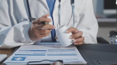 Doktor reçeteyi masaya yazıyor.