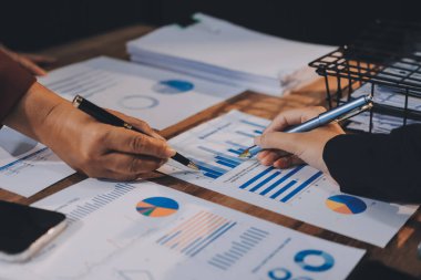 Bir grup iş adamı, analitik plan toplantısında beyin fırtınası yaparak grafikten elde edilen rakamları hesaplıyor. Finansal büyüme tablosu. Pazarlama. İş başarısı istatistikleri kavramı.