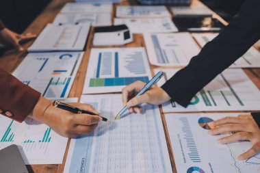 Bir grup iş adamı, analitik plan toplantısında beyin fırtınası yaparak grafikten elde edilen rakamları hesaplıyor. Finansal büyüme tablosu. Pazarlama. İş başarısı istatistikleri kavramı.