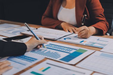 Bir grup iş adamı, analitik plan toplantısında beyin fırtınası yaparak grafikten elde edilen rakamları hesaplıyor. Finansal büyüme tablosu. Pazarlama. İş başarısı istatistikleri kavramı.