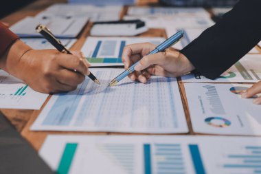 Bir grup iş adamı, analitik plan toplantısında beyin fırtınası yaparak grafikten elde edilen rakamları hesaplıyor. Finansal büyüme tablosu. Pazarlama. İş başarısı istatistikleri kavramı.