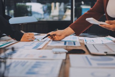 Bir grup iş adamı, analitik plan toplantısında beyin fırtınası yaparak grafikten elde edilen rakamları hesaplıyor. Finansal büyüme tablosu. Pazarlama. İş başarısı istatistikleri kavramı.