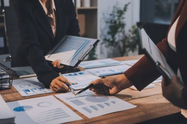 Bir grup iş adamı, analitik plan toplantısında beyin fırtınası yaparak grafikten elde edilen rakamları hesaplıyor. Finansal büyüme tablosu. Pazarlama. İş başarısı istatistikleri kavramı.