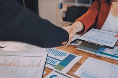 Ofis toplantısında iki farklı profesyonel iş adamı yönetici lider el sıkışıyor.