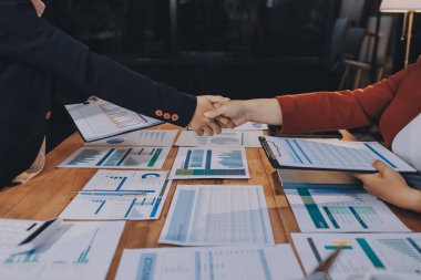 Ofis toplantısında iki farklı profesyonel iş adamı yönetici lider el sıkışıyor.